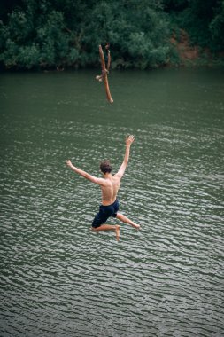 genç adam bir ip ile nehre atlama