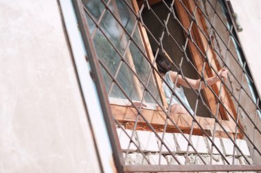 küçük kız, çocuk, barlar pencerenin Rusya, Başkurdistan, Ufa üzerinde tutarak