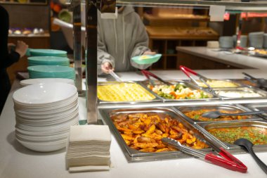 Servis hattındaki servis tabakları, self-servis restoranı. Buharda pişmiş sebze, pirinç, karabuğday, patates. Copispace.