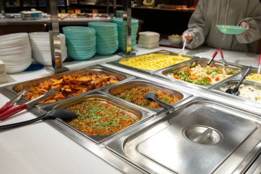 Servis hattındaki servis tabakları, self-servis restoranı. Buharda pişmiş sebze, pirinç, karabuğday, patates. Copispace.