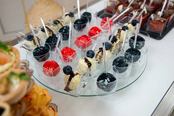 Rows of delicious desserts in beautiful compositions. Sweets on the banquet table - a photo taken during catering. Copyspace.