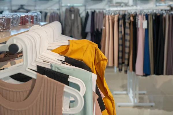 Elegante camiseta de mujer es noqueado en las perchas en la sala de exposición. Espacio de copia — Foto de Stock