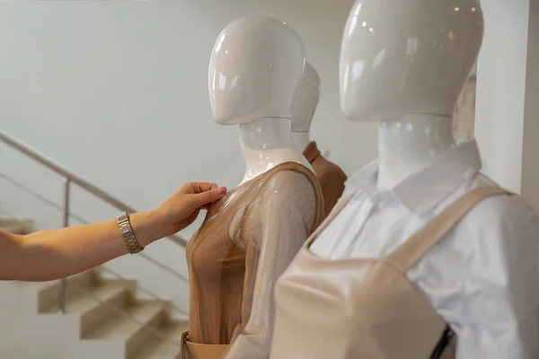 Bir kadının eli, montaja başlamadan önce mankenin üzerindeki kıyafetlere dokunur. Copspace — Stok fotoğraf