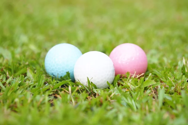 Pallina da golf in cristallo bianco, rosa e blu su erba verde nel campo da golf — Foto Stock