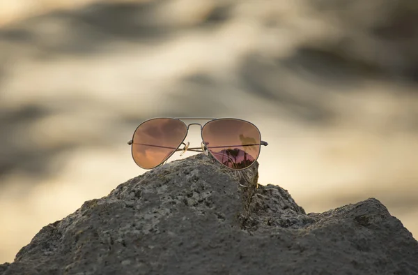 Rock Beach, odak güneş gözlüğü üzerinde kırmızı güneş gözlüğü — Stok fotoğraf