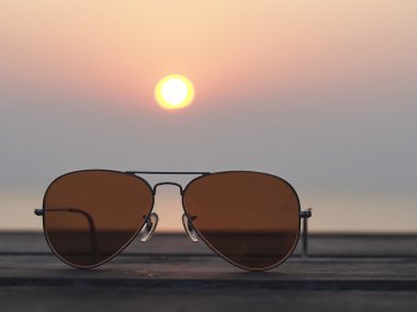 Closeup gözlük ile üzerinde duruldu ve gün batımı manzaralı bulanık