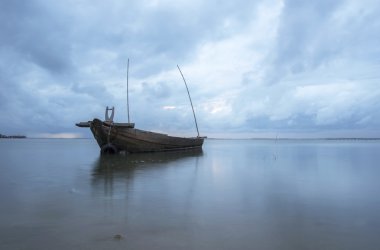 Alacakaranlık ve günbatımı balıkçı teknesi ve kargo ile denizde gemi