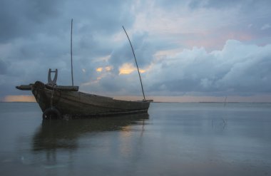 Alacakaranlık ve günbatımı balıkçı teknesi ve kargo ile denizde gemi