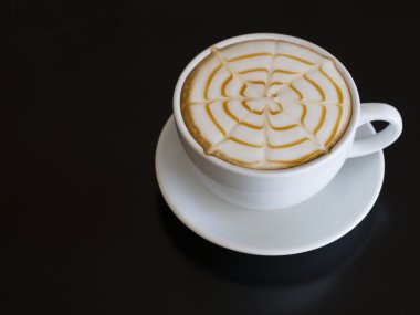 Kahve fincanı ahşap masa arkasında.