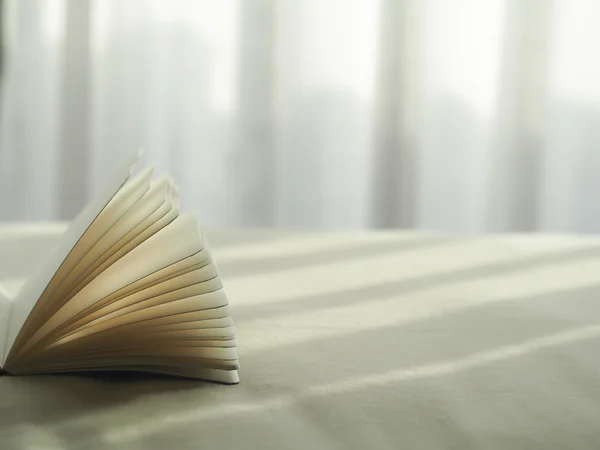 Verse ochtend boek lezen op het bed, selecteer focus. — Stockfoto