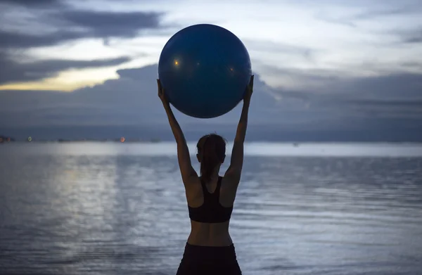 Siluet yoga topu yong kadın plaj gün batımı adam — Stok fotoğraf