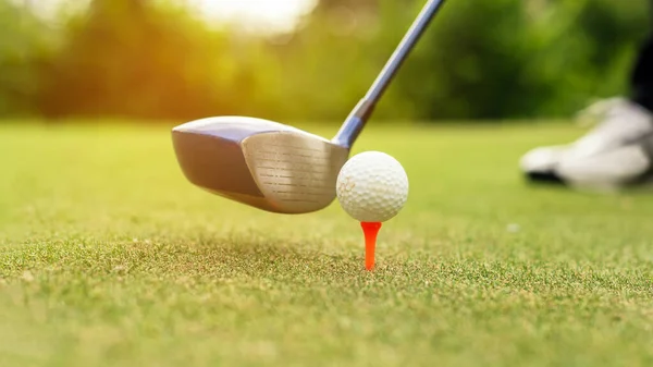 Close up Golf club hitting golf ball along fairway towards green with copy space, green nature background. Lifestyle and Healthy Concept.