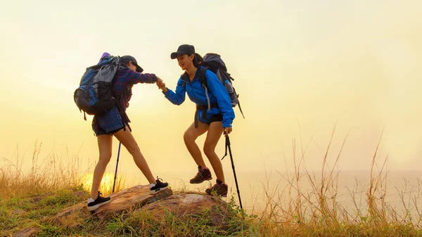 一群年轻的女徒步旅行者 日落时背着背包在山上散步 旅行者外出露营是为了休闲 旅行概念 — 图库照片