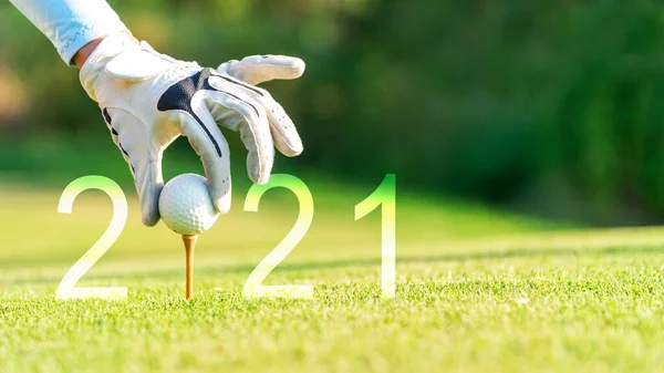 Golfer woman putting golf ball for Happy New Year 2021 on the green golf for new healthy.  copy space. Healthy and Holiday Concept.