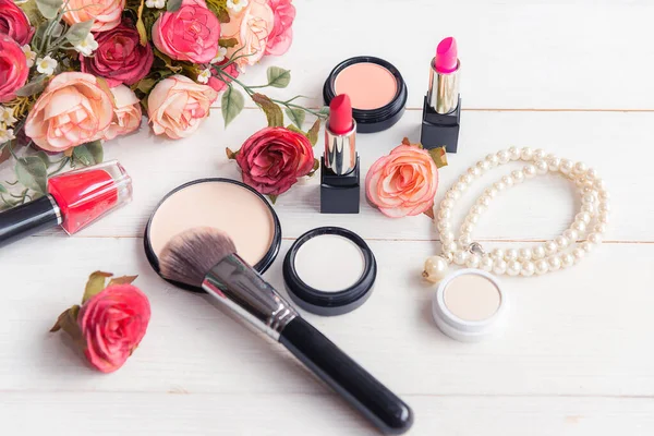 Gift Cosmetic.  Makeup cosmetics tools background and beauty cosmetics, products and facial cosmetics package lipstick, eyeshadow with pink rose and pearl necklace on the white background, vintage tone.  Lifestyle Concept