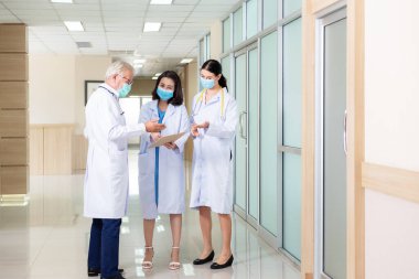 Bir grup tıbbi personel koridor hastanesinde tartışıp rapor veriyor. Sağlık Uzmanı Alma ve Teselli