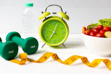 Diyet Sağlık Planı. Antrenman planına başla. Spor aletleri, spor aletleri, beslenme, taze salata ve spor için yeşil elma.
