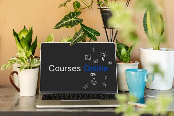 Course Online text on laptop screen on table with plant and coffee cup in the nature garden at home. Technology and Education Concept