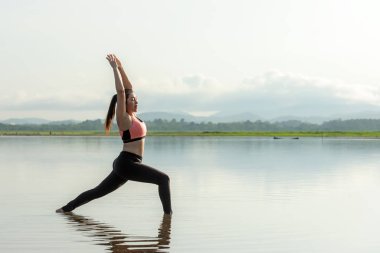 Yoga kadın yaşam tarzı egzersizi ve sağlıklı yaşam için poz vermek. Genç kız ya da insanlar vücut dengesini dengelemek için Zen ve meditasyon için güneşin doğuşunu hazırlıyorlar. Sağlık Hizmetleri Konsepti