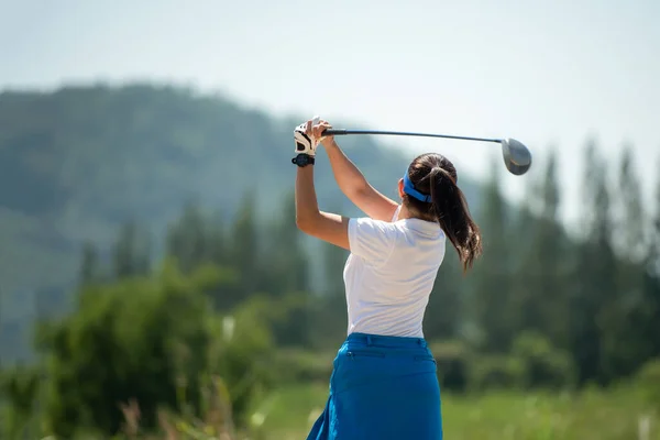 Golfer sport course golf ball fairway. People lifestyle woman playing game golf and hitting go on green grass river and mountain background. Asia female player game shot in summer. Healthy and Sport