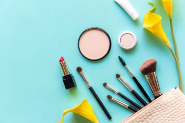 Makyaj malzemeleri ve güzellik kozmetik hediyeleri, ürünler ve yüz kozmetik paketleri mavi arka planda sarı zambak çiçekli ruj, üst manzara ve kopyalama alanı. Yaşam Tarzı Güzellik Konsepti