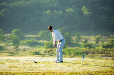 Golf sahası golf sahası sahası. İnsanlar yeşil çimlerin üzerinde golf oynayan bir yaşam tarzı adamı. Yazın Asyalı oyuncu vuruşu. Sağlıklı ve açık hava sporu