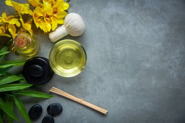 Tayland Spa 'sı. Sıcak taşlar masaj için hazırlanıyor ve tahtanın üzerinde sarı orkide ile rahatlıyor. Yaşam Tarzı Sağlıklı Kavram, afiş için kopyalama alanı, üst görünüm