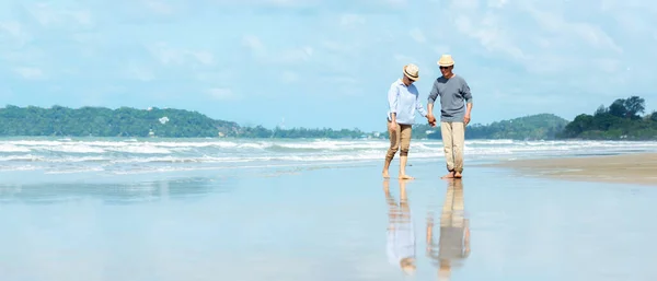 Asian Lifestyle senior couple walking chill on the beach happy in love romantic and relax after retirement.  People tourism elderly family travel leisure and activity after retirement in vacations