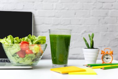 Healthy working in office.  Fresh vegetable salad with fresh vegetable smoothes  for diet Health Plan with laptop on white dress working.  Healthy eat for working in office.   Healthy Lifestyle Concept