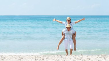 Romantik aile Asyalı çiftler yaz tatilinde plaj yakınlarındaki lüks bir tatil köyünde rahatlayıp balayının tadını çıkarırlar. Turizm turizmi, tatil beldesi, tropik ada. Seyahat Gezileri Konsepti.