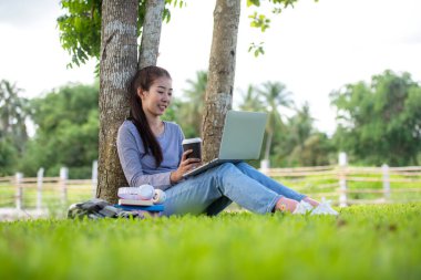 Gençler evde dizüstü bilgisayarla çalışıyor ve sabahları kahve içiyor. Doğa bahçesi evinde rahatlıyorlar. Asyalı kadın toplantı konferansı ofisi internet üzerinden bağlıyor. İş ve Teknoloji Konsepti