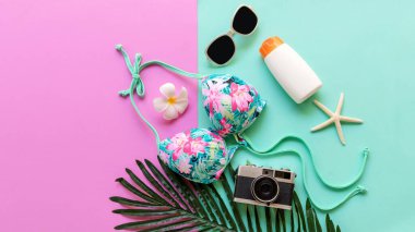 Yaz eşyaları ve aksesuar gezgini kadın renkli bikini, kamera plajda seyahat planı tatiline gidiyor. Tropik deniz. Alışılmadık üst görünüm, Seyahat ve Yaz Konsepti.