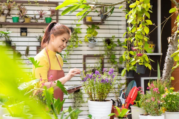 Woman receipt order customer and sale plant flower online on laptop in garden. People hobby and freelance gardening indoor at home, nature garden background. Happy and enjoy in spring and summer day