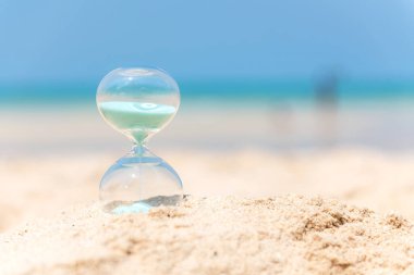 Kum saati yaz ve tatil zamanında bir plaj kum mavi gökyüzü ve kopya alanı ile. Yaşam tarzı kavramı.