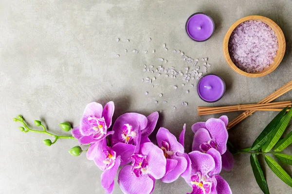 Tayland Spa Tedavileri aroma terapisi tuz ve şeker masajı. Sırt tahtasında mor orkide çiçeği ve mum var. Tayland. Sağlıklı Konsept.