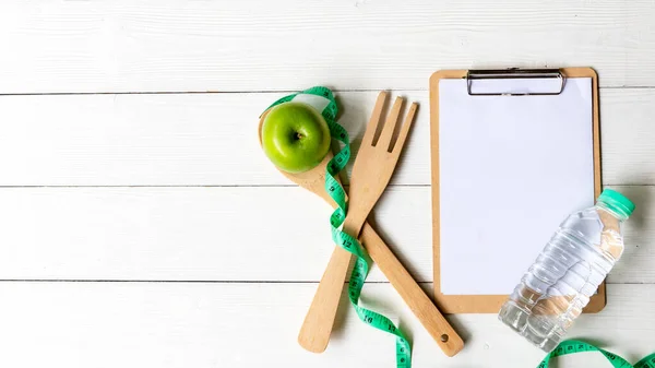 Planning for Diet Health eat and food.  Green Apple and measuring tape, note pad for fitness style. Nutrition Healthy Lifestyle Concept, Top view and copy space