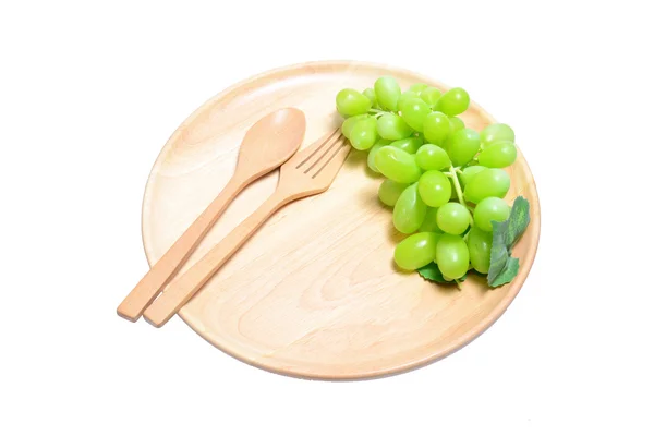 新緑のブドウは木製皿、白背景に分離した構成 — ストック写真