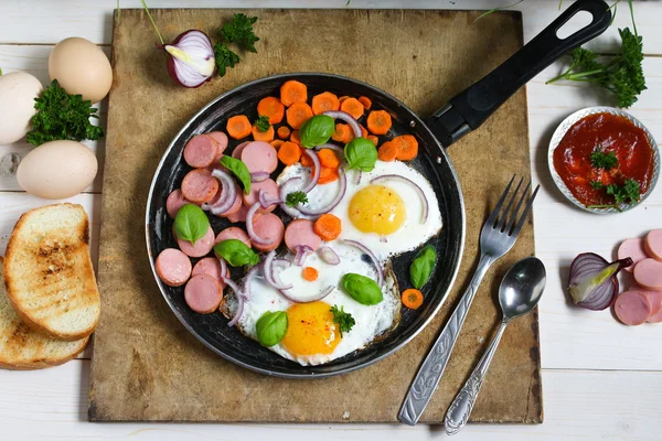 Fried eggs in a frying pan with vegetables — Stock Photo, Image