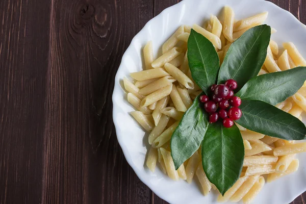 Bir porsiyon makarna ile dekore edilmiş yaprakları ve meyveleri