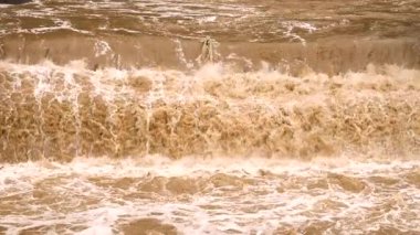 Yağmur ve fırtınadan sonra akan çamurlu ve bulanık dere görüntüsü.