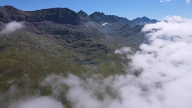 Sisli bulutlu dağların ve krater gölünün insansız hava aracı görüntüleri.