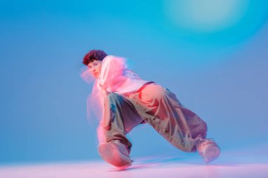 Hip hop dansçısı hareket bulanıklığı ve neon jel ile çekilmiş, müzik tanıtımları, festival posterleri, gençlik kültürü reklamları ve sosyal medya kampanyaları için mükemmel..