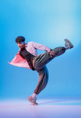 Hip hop dansçısı renkli stüdyo ışıklarına güçlü bir tekme attı. Müzik tanıtımları, posterler ve şehir gençlik kampanyaları için ideal..