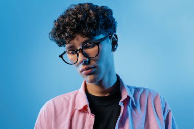 Gözlüklü düşünceli bir gencin yakın portresi, zihinsel sağlık, stres, tükenme, danışmanlık ve refah farkındalığı projeleri için ideal..