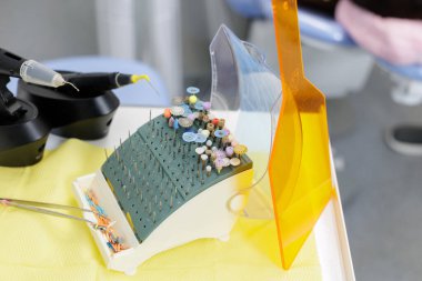 Endodontik bur bloğunun bitiş noktaları ve engelleme araçlarının yanında hafif kalkanla yakın görüntüsü, kök kanal tedavisine hazırlık gösteriyor