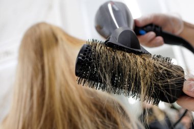 Yoğunlaştırıcı hava akışı, şekillendirme hacmi ve uzun kuaför saçında pürüzsüz bir kapanış ile yuvarlak fırça kurutma.