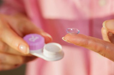 Yumuşak kontakt lenslerin parmaklarda, açık kutular kadın ellerindeyken kapatılması, evde günlük hijyenik görüş düzeltmesi kavramı