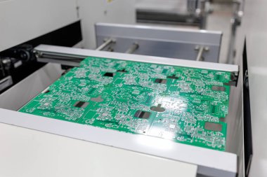 Fabrika atölyesindeki modern elektronik imalat makinesinde yeşil baskılı devre paneli konveyör üzerinde hareket ediyor