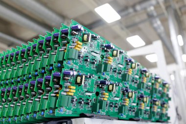 Modern otomatikleştirilmiş fabrikada elektrik elektronik bileşenleri olan yeşil baskılı devre kartları.