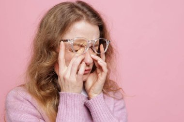 Gözlük takan kadın portresi kuru göz tahrişi ve ekran yorgunluğundan dolayı baş ağrısı gösteriyor.